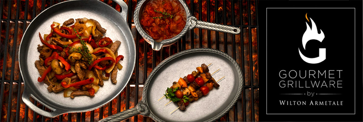 Beef and peppers sautéed in a skillet and vegetable skewers on a grill beside the Gourmet Grillware by Wilton Armetale logo.
