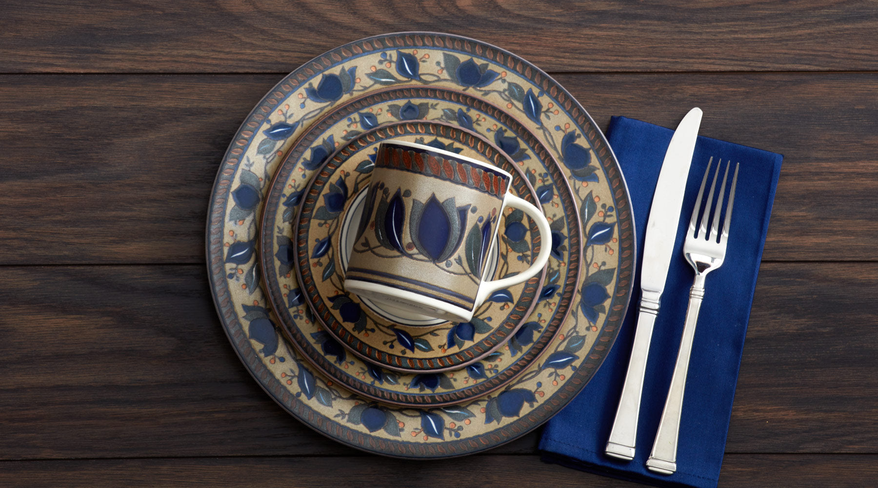 Arabella dinnerware brings casual style to your table with simple white centers and rims of boldly stylized navy blue tulips and vines on rustic beige backgrounds.