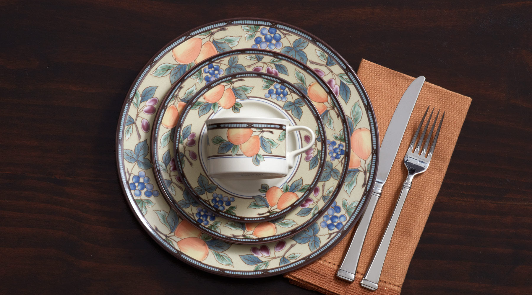 Colorful fruits and leaves by the bushel enliven the table with the tones of an orchard.